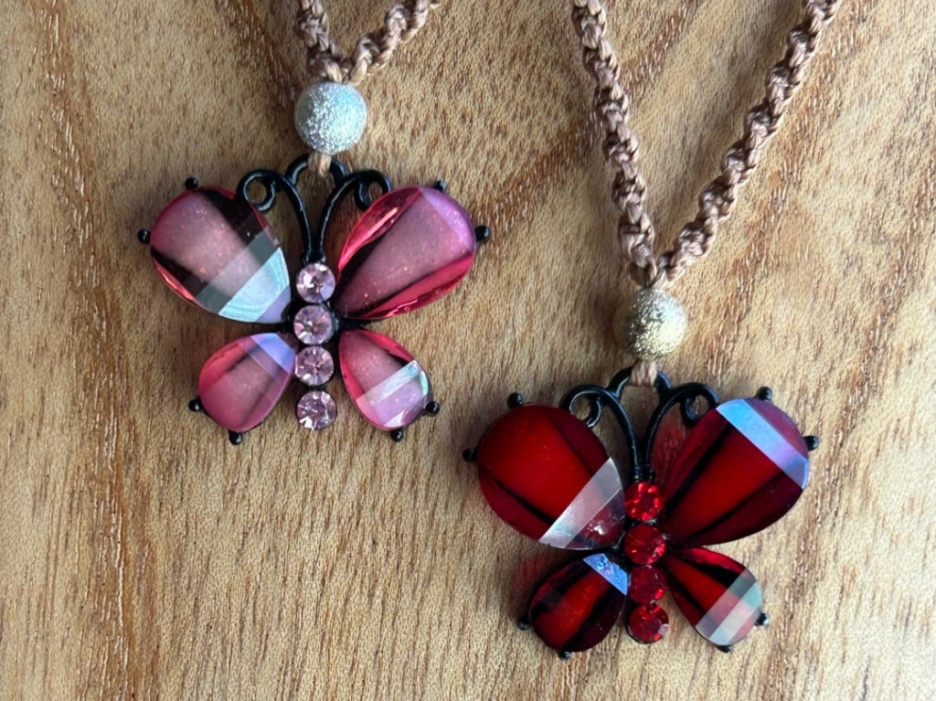 ピンクと赤の蝶を並べると印象の違いが際立つ。ピンクは銀のビーズ、赤は菌のビーズを触覚上部に飾ってある。