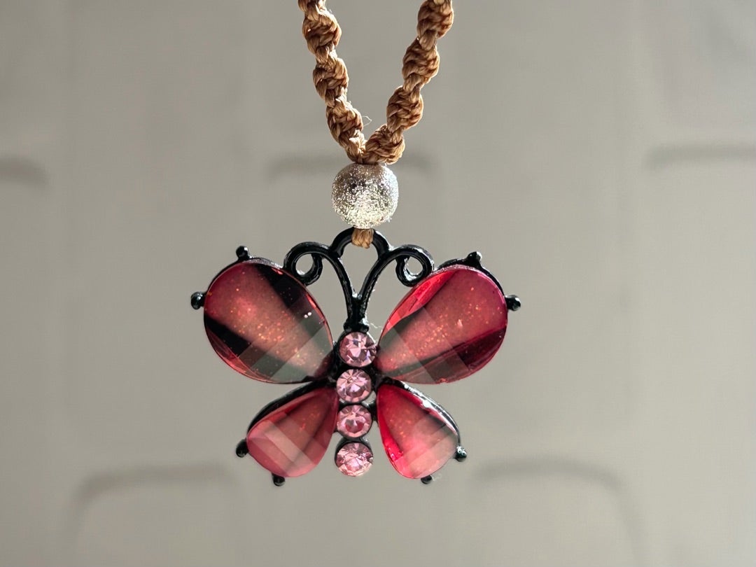 バランスよく羽を広げているピンクの蝶。瑞々しい透明で表面にはカットが施され細かな反射が起きる。